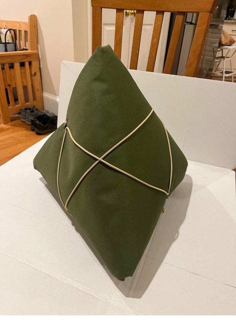 The Zong Zi wrapped closed into a green triangular bundle, cord crossed over the front.